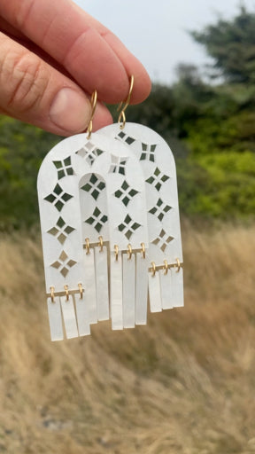 Arches and Fringe cut-out earrings in pearl-sheen acrylic with brass